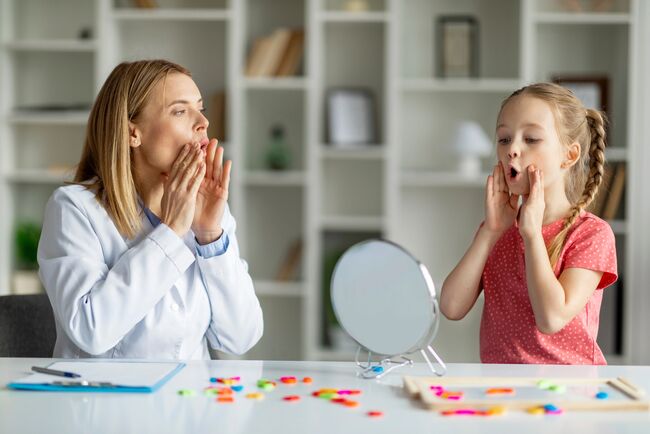 Professional child specialist woman training with little girl at cabinet